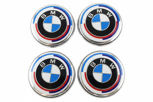 Four BMW emblems on a textured surface