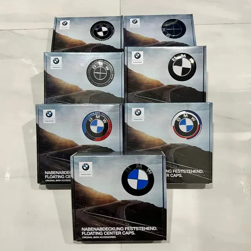 Collection of BMW car center cap packaging on a reflective surface